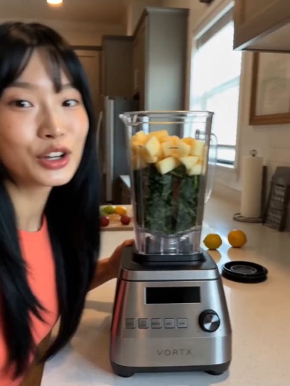 A blender full of fruit on a kitchen counter